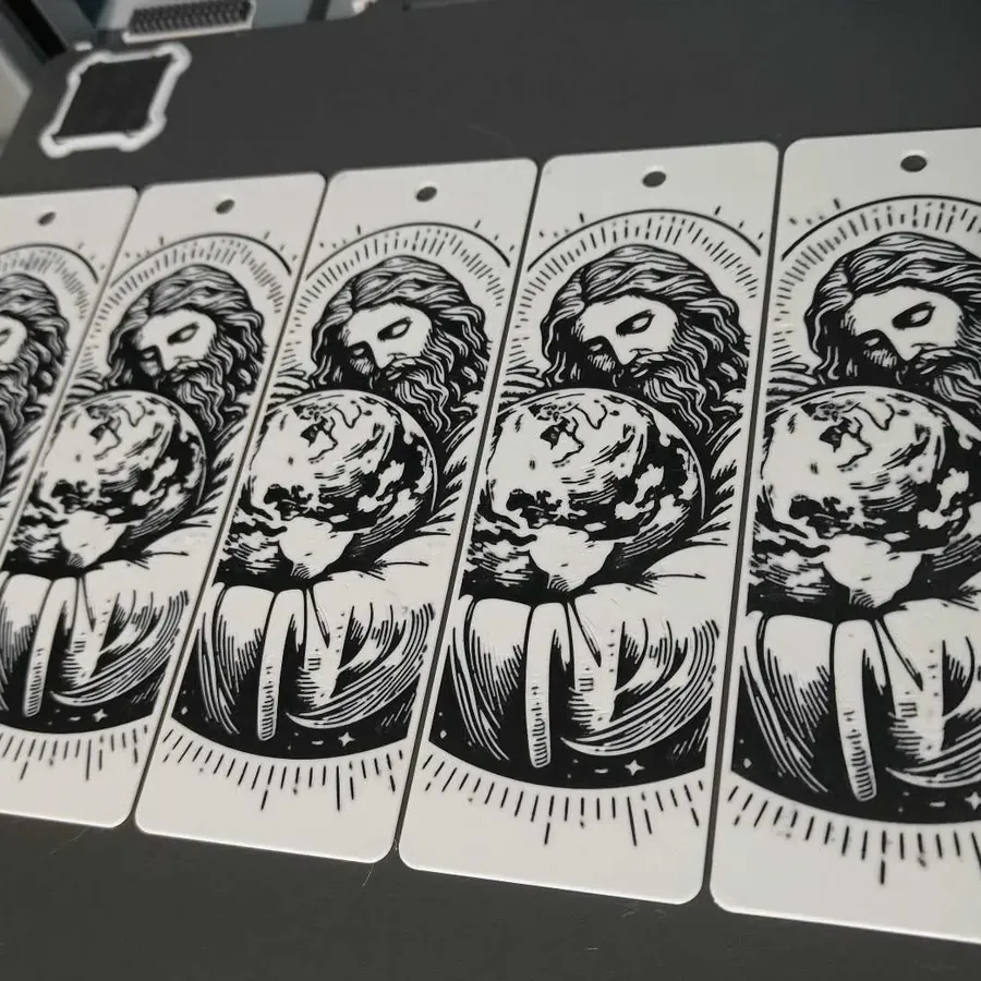 Marcadores Jesus e o Mundo recém-impressos, ainda na mesa da impressora 3D